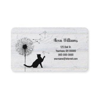 Black cat with dandelion on wood