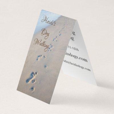 Footprints and dog paw prints in the sand