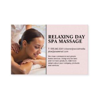 Masseuse giving back massage to woman on spa table