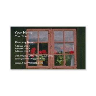 Violet Geraniums In The Window Of A Traditional Ho